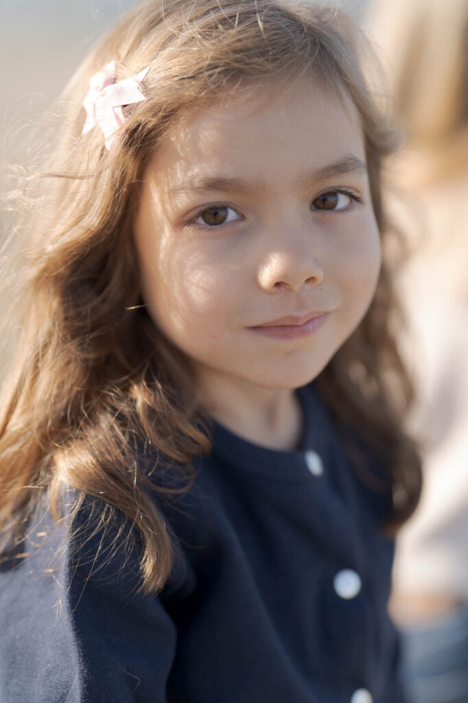 Cute little girl with pretty eyes and glistening hair in the sun.