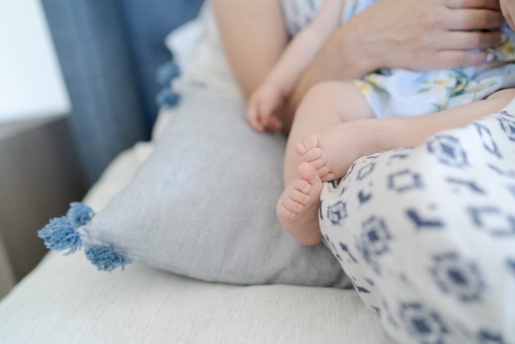 Mom holds a newborn baby on her lap.