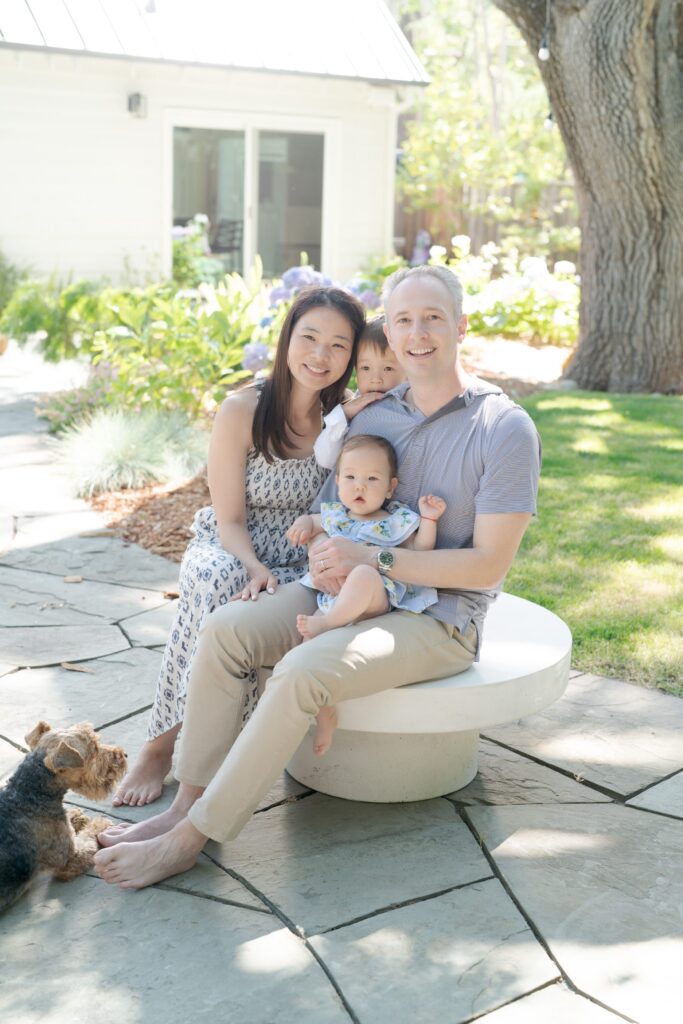 Happy family of four stick together and pose alongside their family pet dog for Robin Jolin's camera.