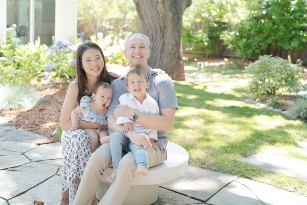 Candid photoshoot of a mom and dad holding their daughter and son in the garden pavement.