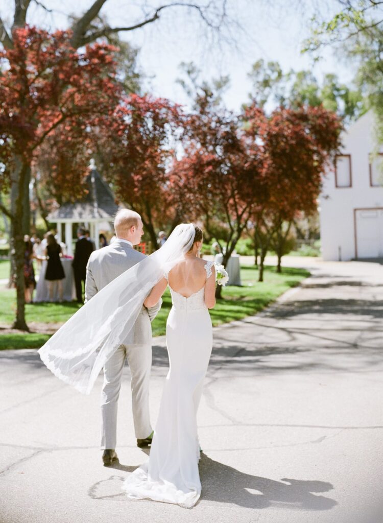 A married couple walking around the courtyard after their wedding ceremony.