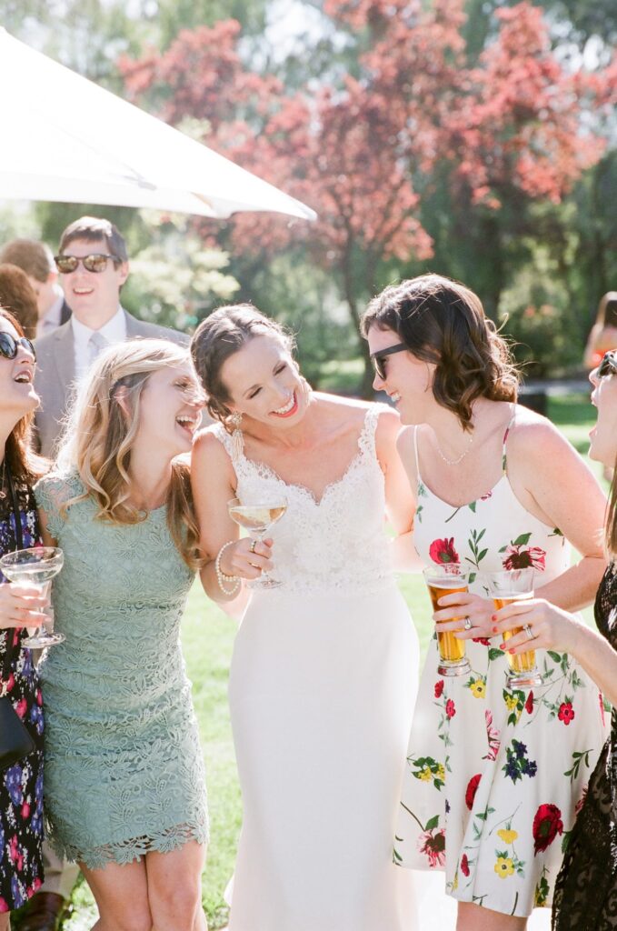 A bride laughing with her friends at the wedding reception.