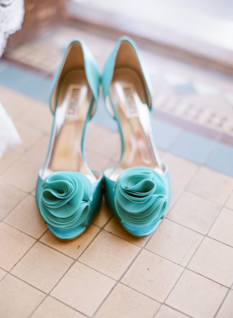 Green wedding shoes on a tile floor.