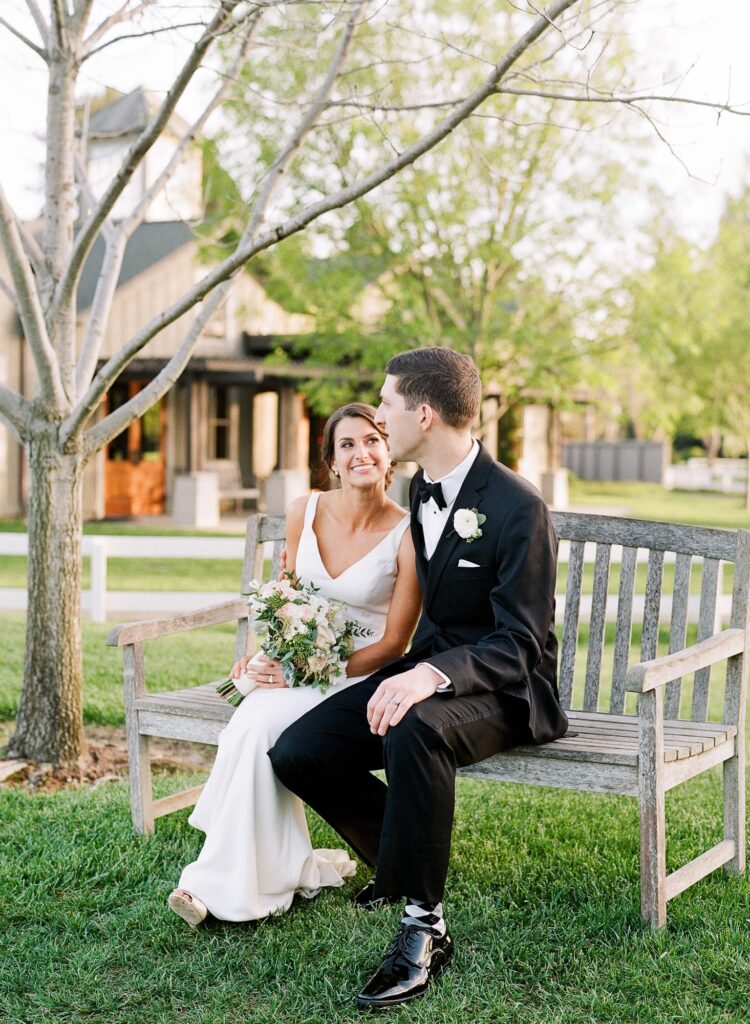 Wedding couple sit on a vintage bench at the Menlo Circus Club.