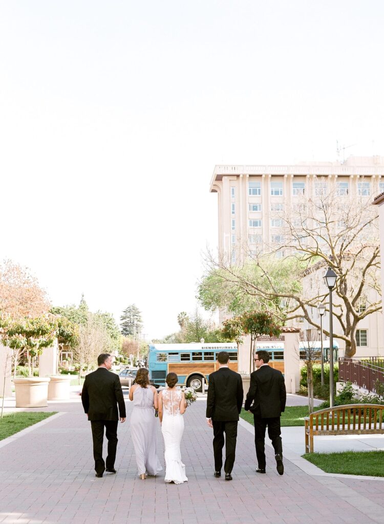 color image of a couple on their wedding day walking to their car. 