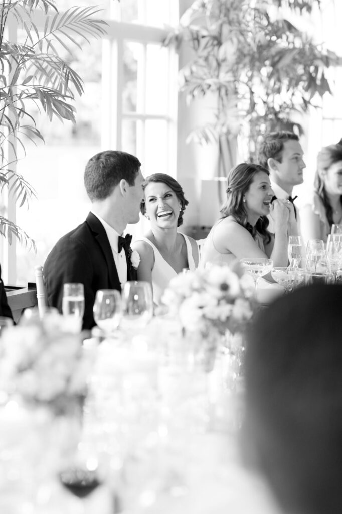 Bride and groom laughing and having a good time at the wedding table during reception.