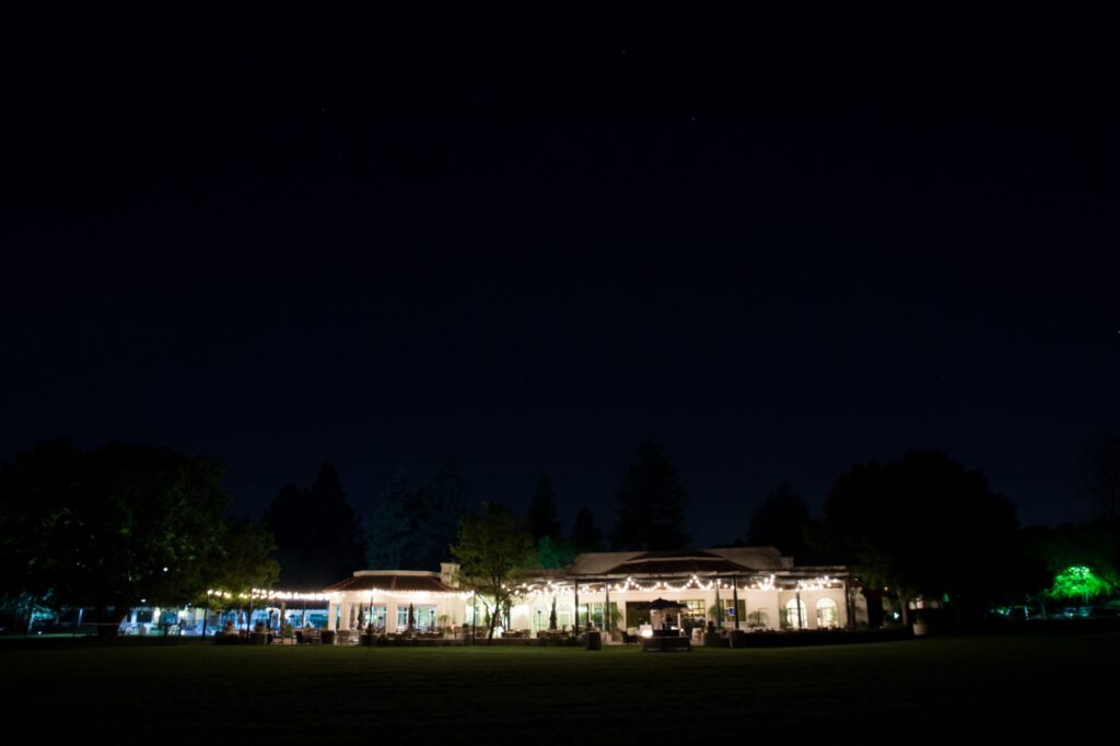 A night time picture of Menlo Circus Club with garden lights and a dark blue night sky.