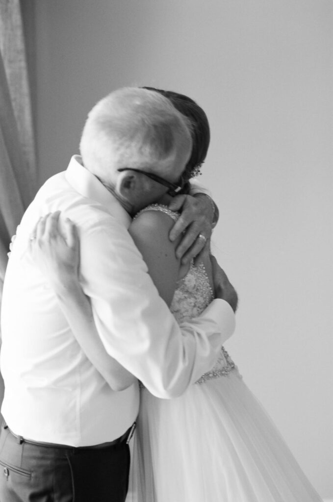 father of the bride hugging his daughter before her wedding. 