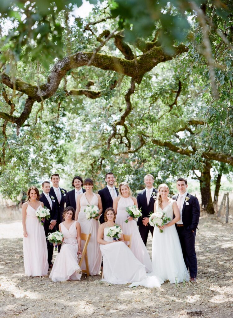 bridal party under an oak tree about to. have a wedding ceremony. 