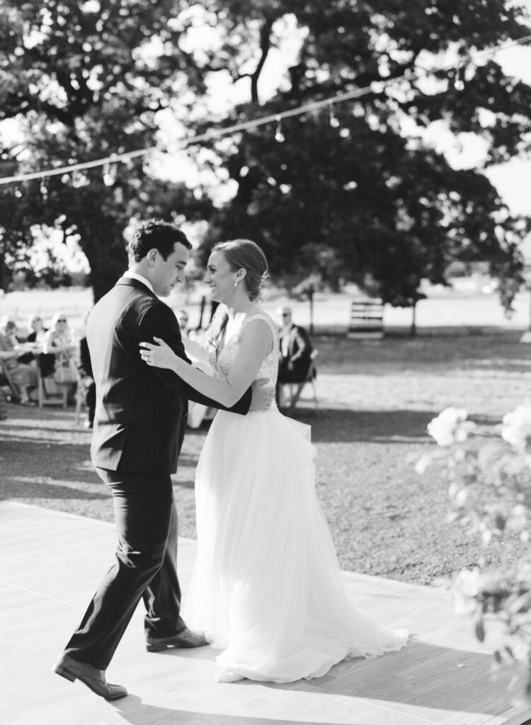 black and white image of a bride and groom dancing at their wedding