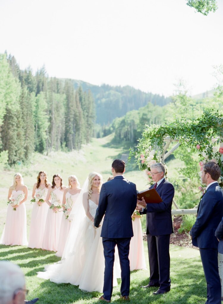 Beautiful outdoor wedding ceremony in Utah with bride, groom, bridesmaid, best man, and an officiant.