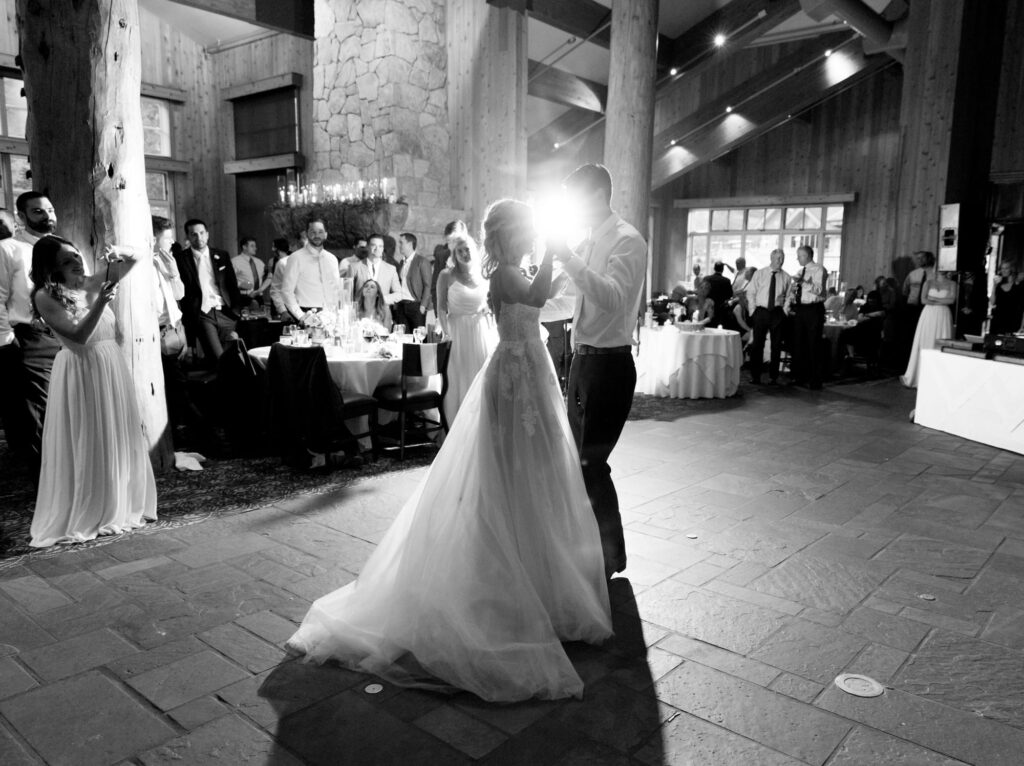 Newly-wed couple perform their first dance as guests watch in awe.