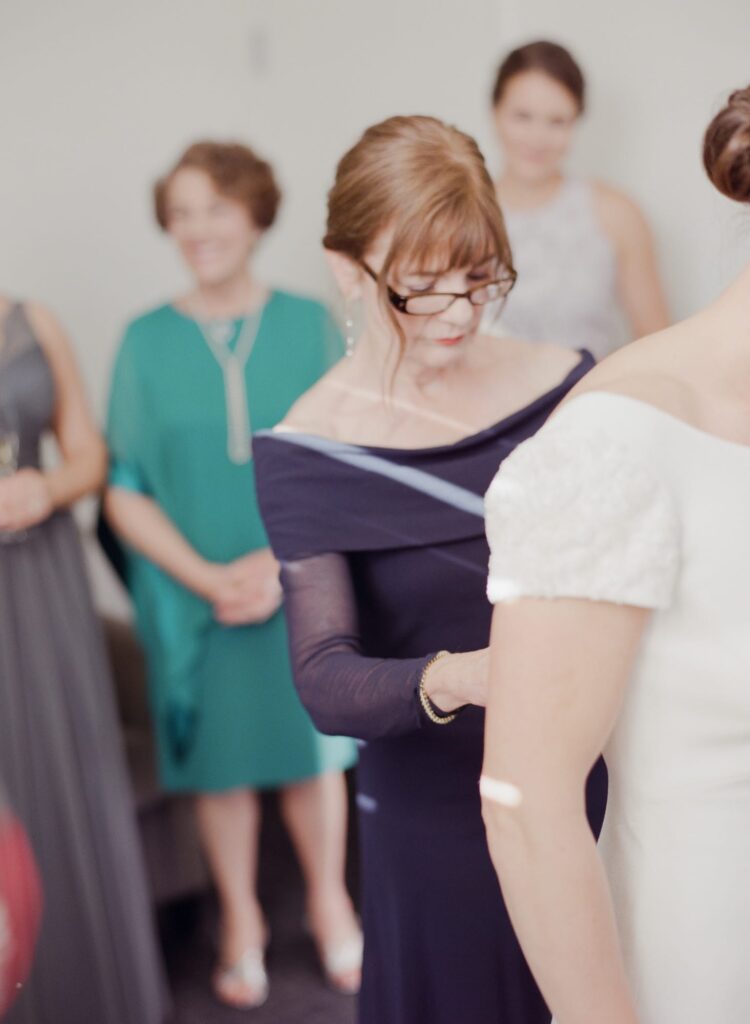 Maid helps the bride prepare for her Marin County Wedding