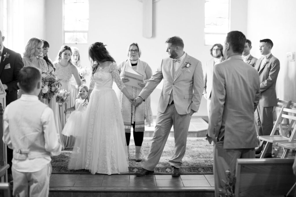 Officiator watches bride and groom in a church.