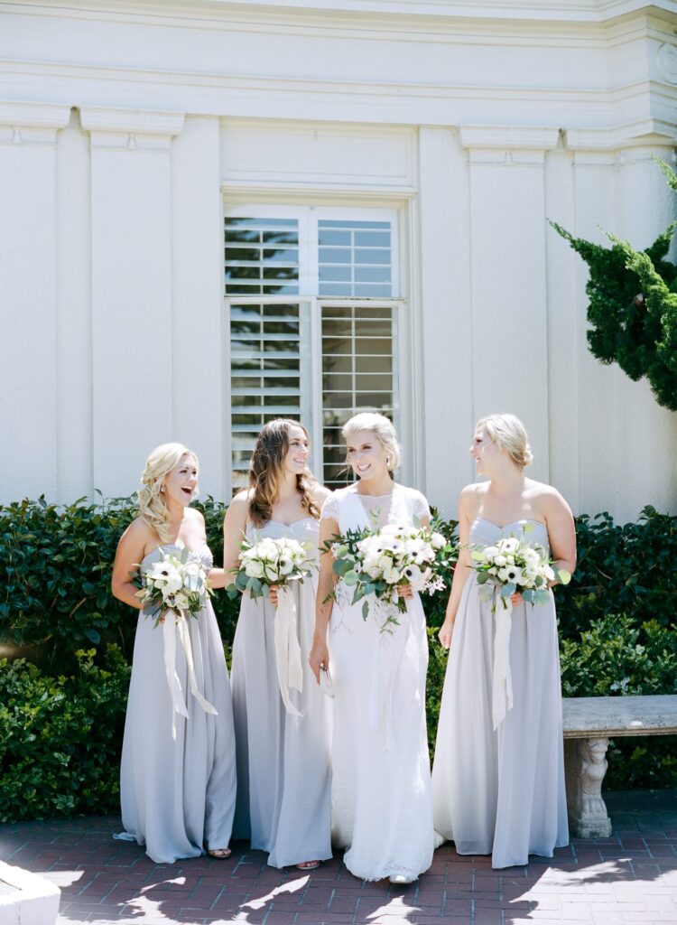 Bride prepare for a picture with her bridesmaids.