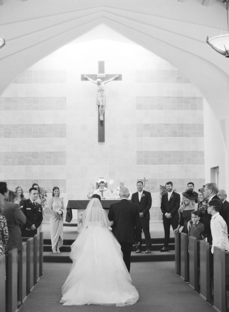 Father walks her daughter down the aisle in a church for her Piedmont Wedding.