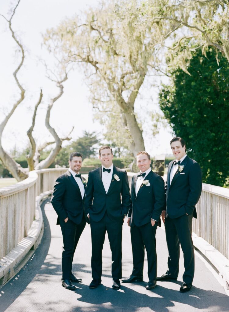 Best men suited in black suits and a bow tie.