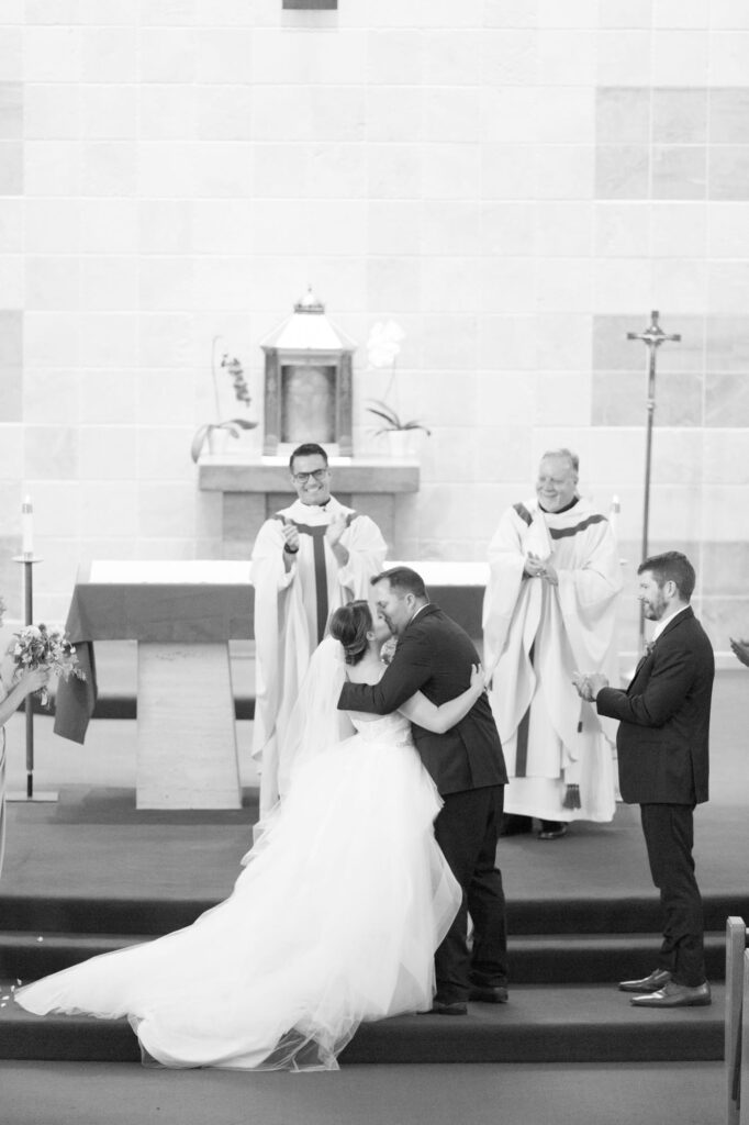 Newly pronounced husband and wife kiss at the church.