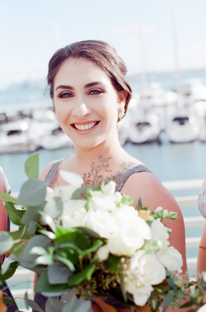 Smiling bridesmaid hold a flower bouquet.