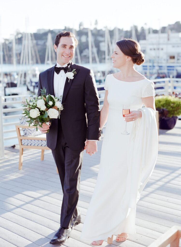 Newly married bride and groom hold hands in Tiburon.