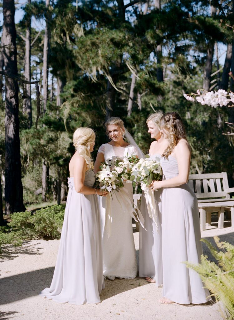 Bridesmaids come together with bouquets for a chat.