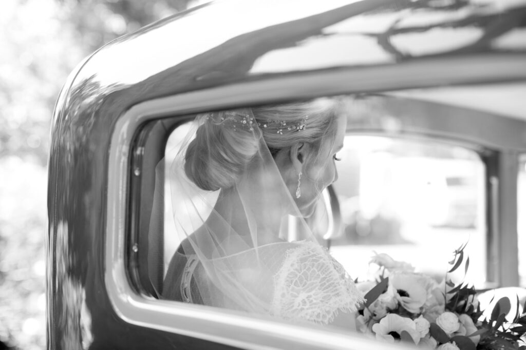 Bride in a classy vintage car to her wedding.