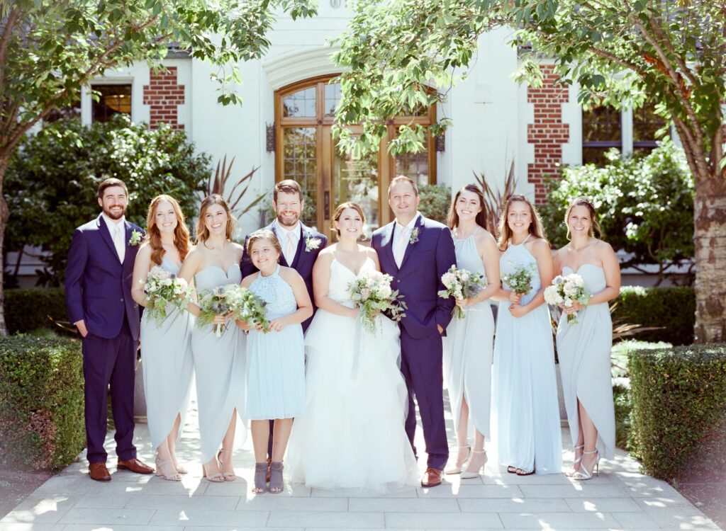 Bridesmaids and groomsmen unify together for a photo.