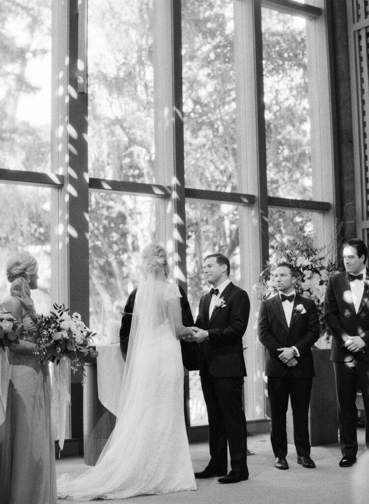 Bride and groom hold hands at the wedding ceremony.