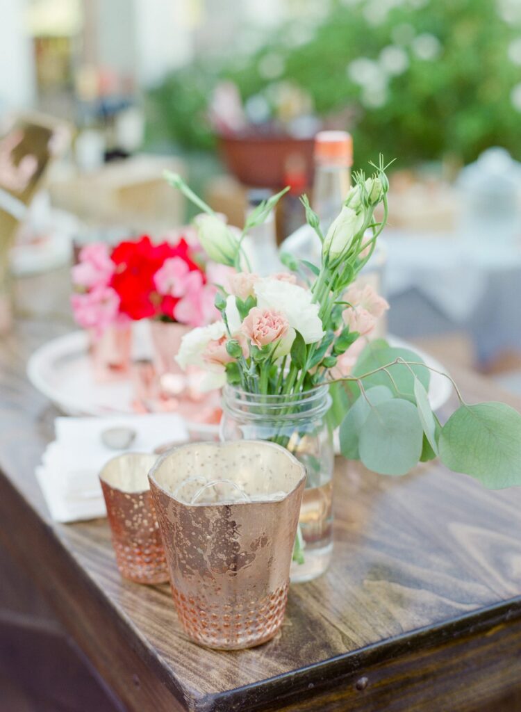 Pretty wooden tabletop with candles and flower vases.