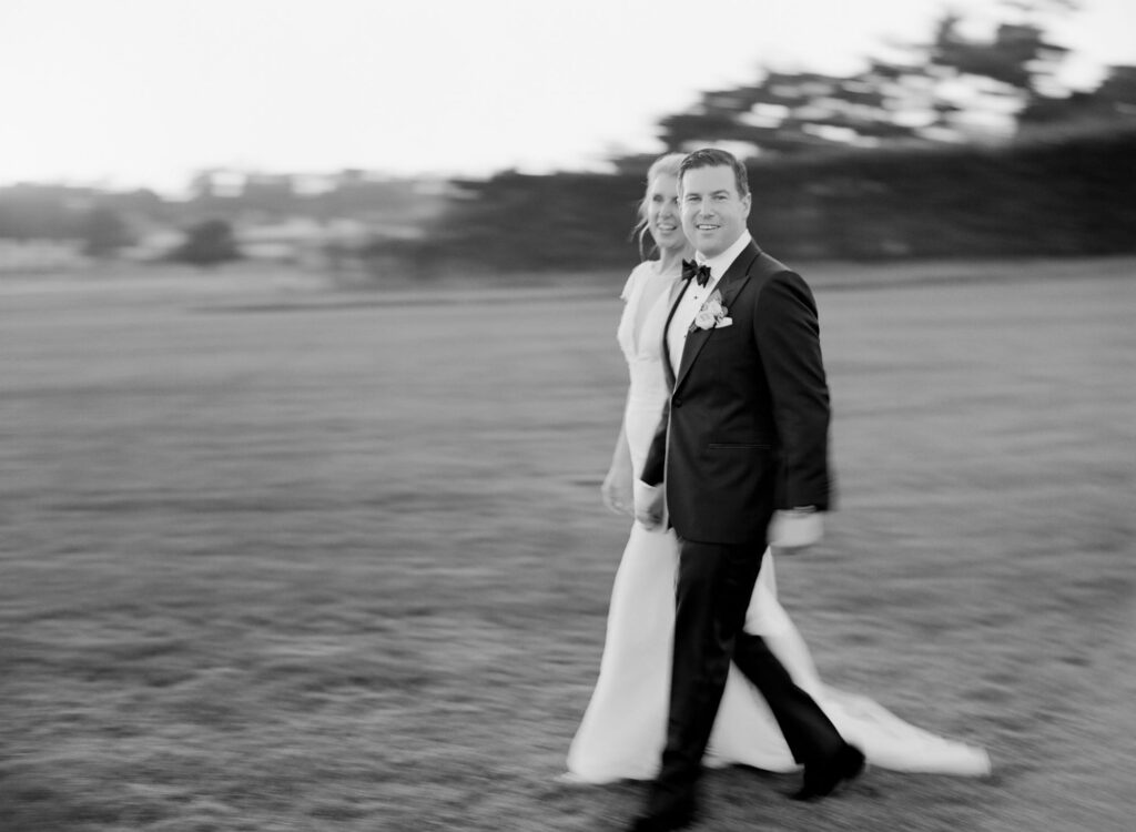 Bride and groom walk in wedding attires at the garden.