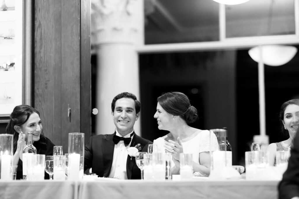 Newly married husband and wife sit at the reception table.