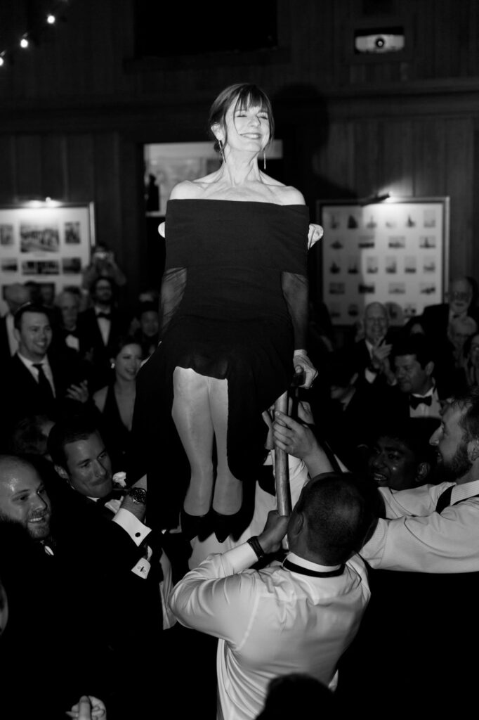 Wedding guests also lift a lady guest with her chair, a traditional wedding practice.