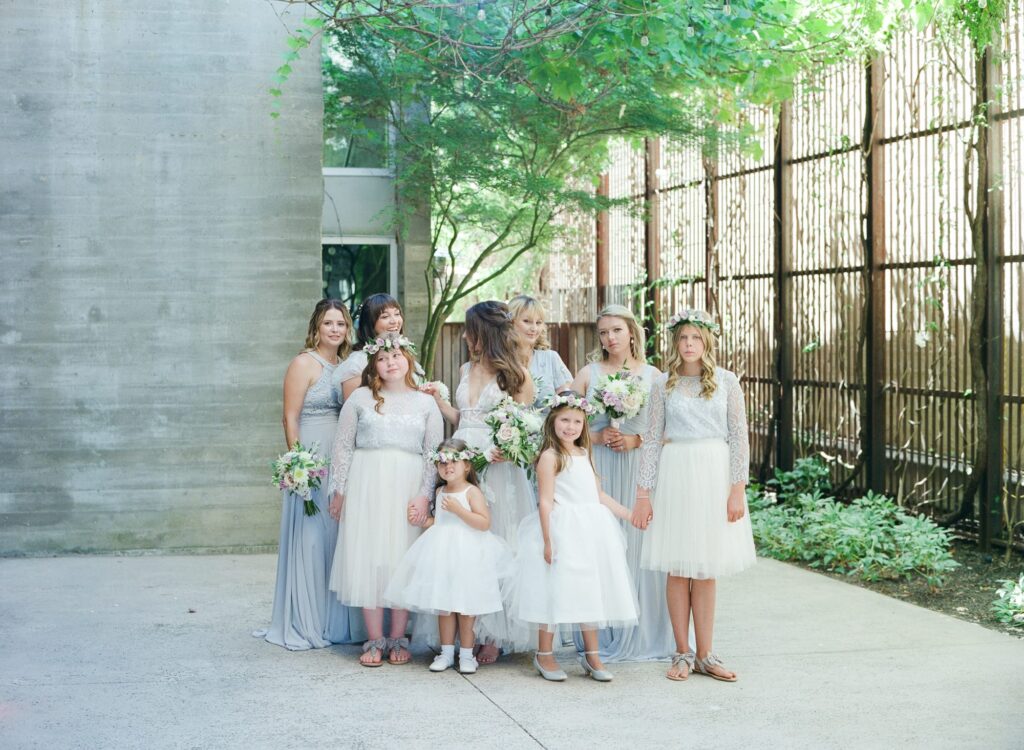 Bride with her bridesmaids and little girls in gowns.