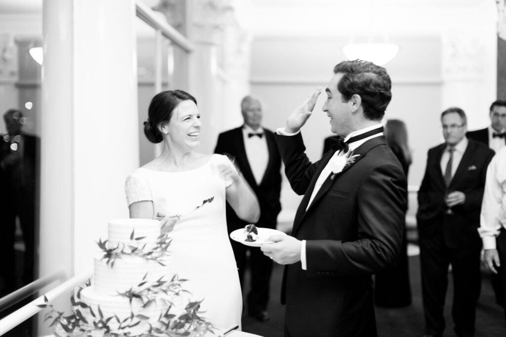 Bride and groom have fun in the cake cutting ceremony.