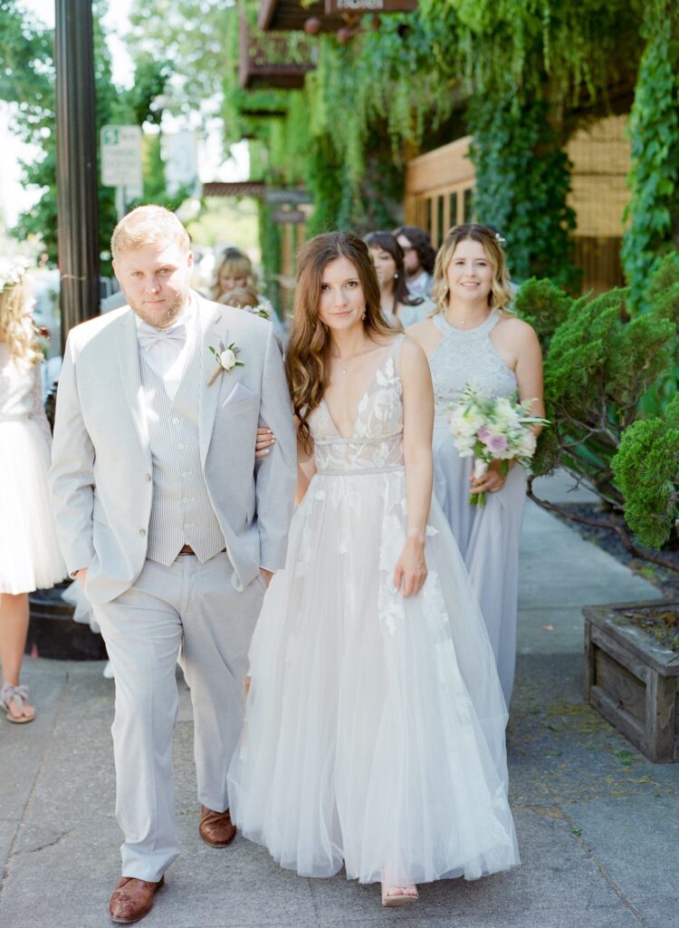 Bride and groom hold hands and walk towards Robin Jolin's camera.