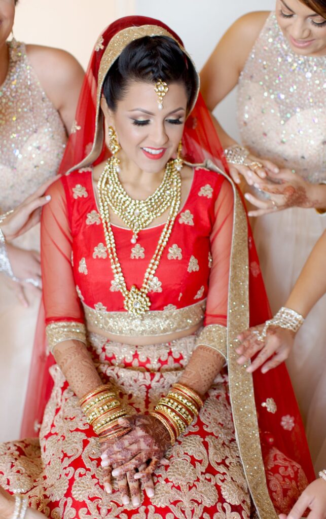 Bridesmaids attend to the Indian bride.