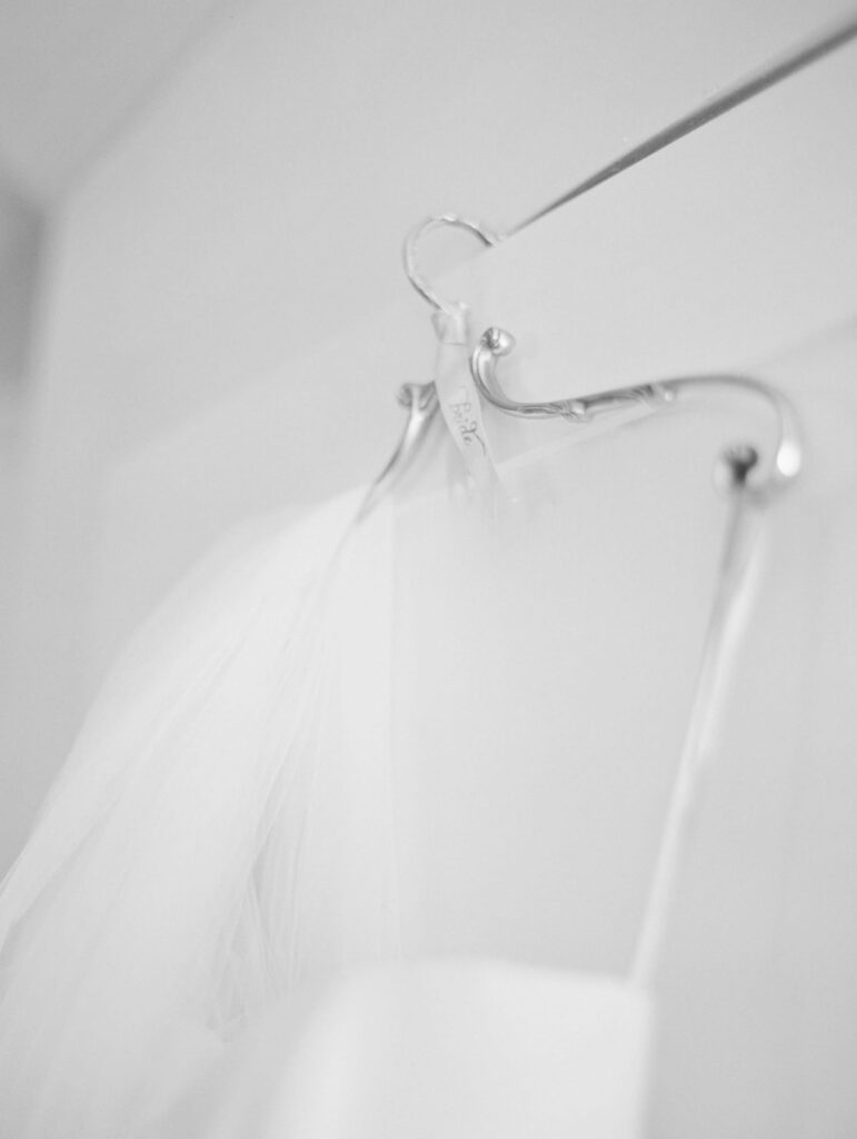 Wedding gown hung on a hanger.