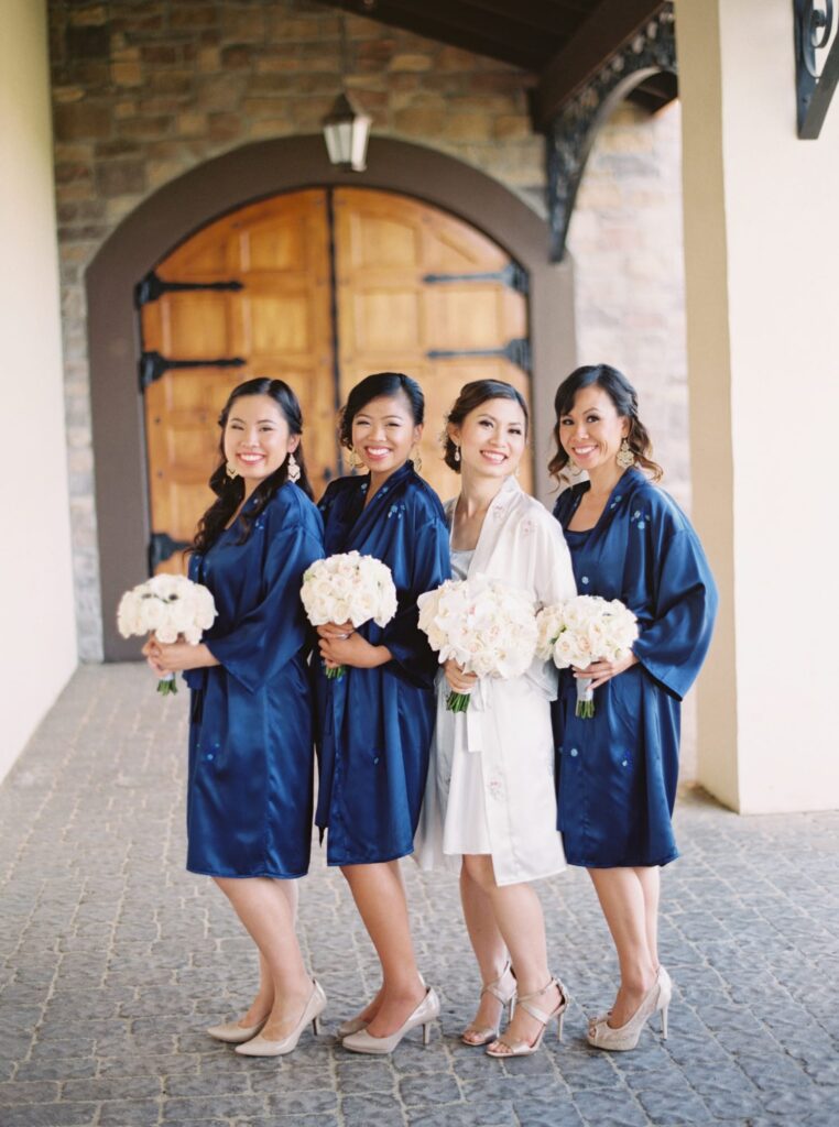 Bride-to-be and her bridesmaids hold flower bouquets.