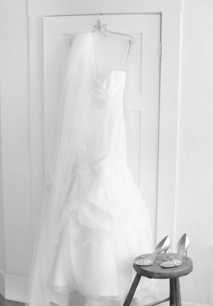 Beautiful white wedding gown beside wedding sandals.