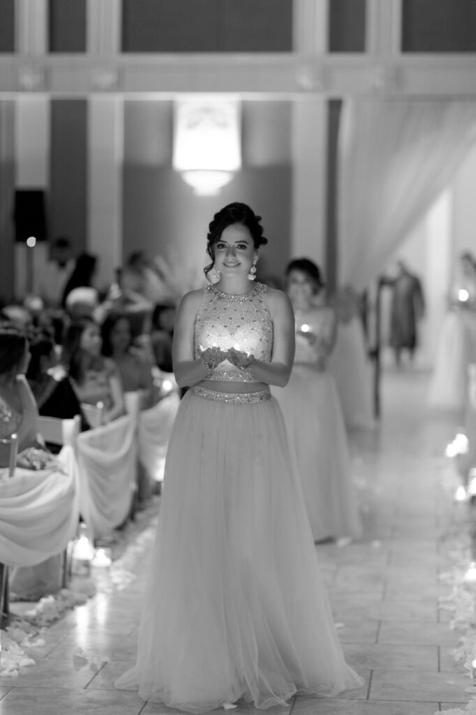 Bridesmaids bring "diya" lamps to the officiation ceremony.