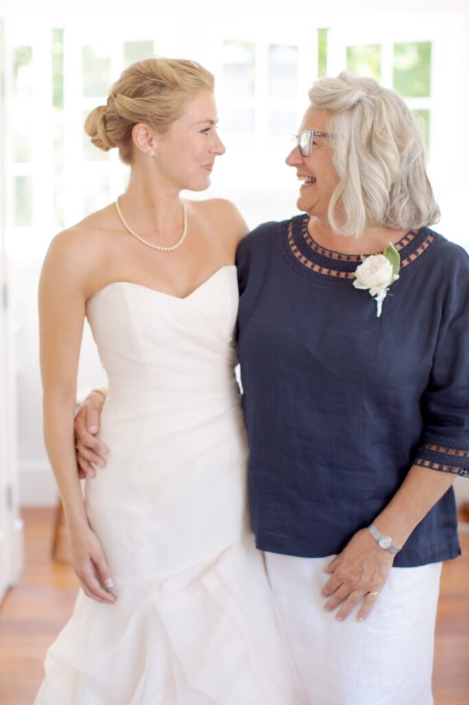 Bride-to-be and her mother look at each other and smile joyfully.