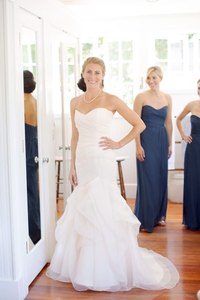 Bride poses for the camera in her wedding gown right before walking down the aisle.