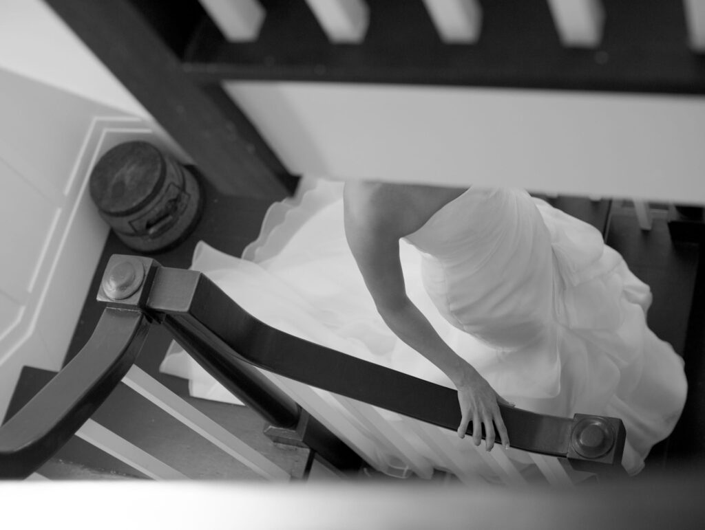 Aesthetic picture of a bride-to-be in wedding gown walking up the stairs.