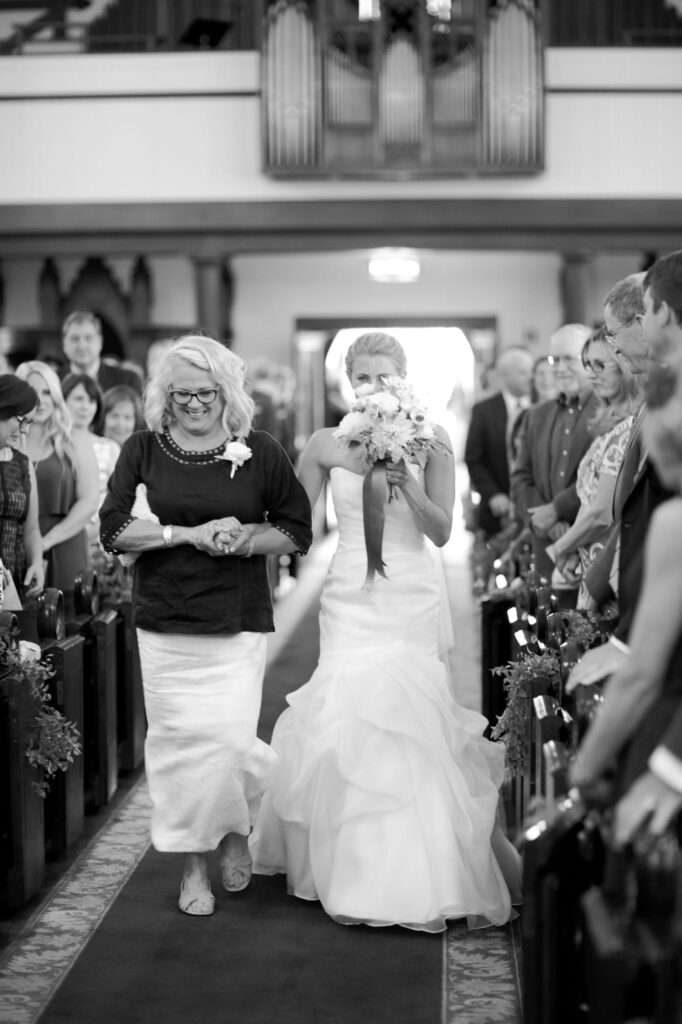 Mother of the bride walks her down the aisle.