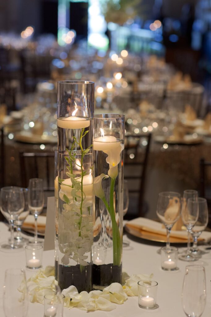 Candle and flowers arrangement at a dining table.