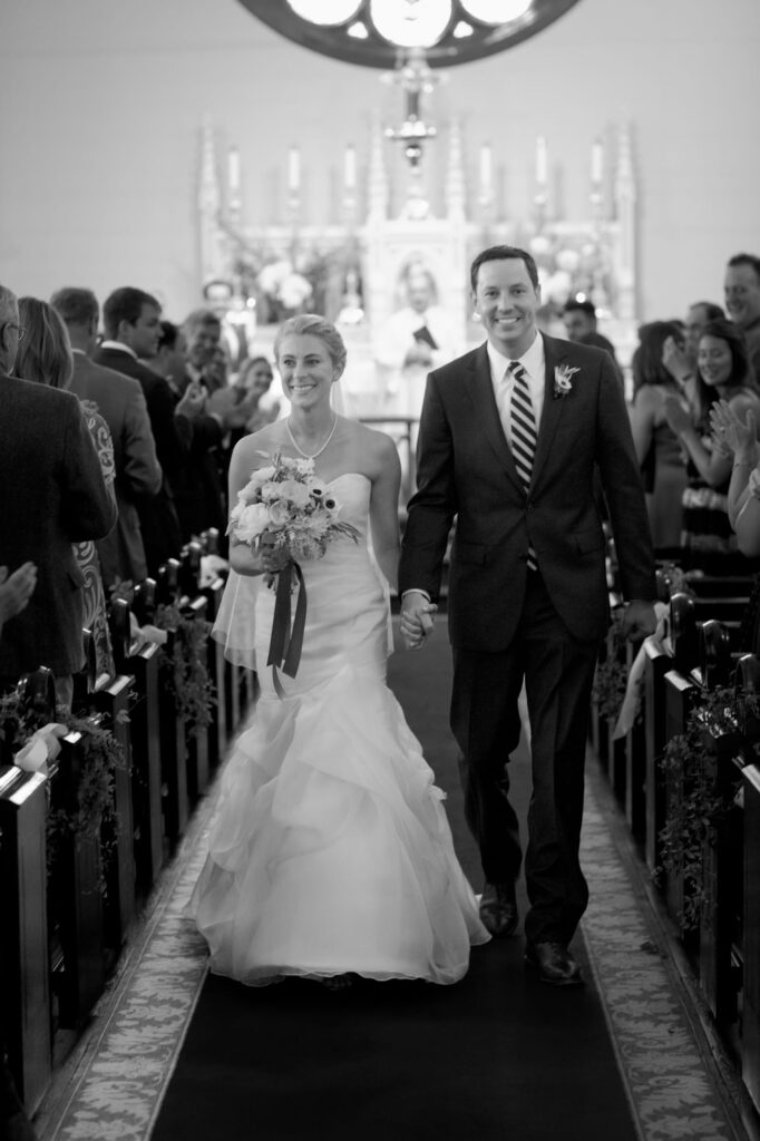 Newly pronounced husband and wife walk back up the aisle.