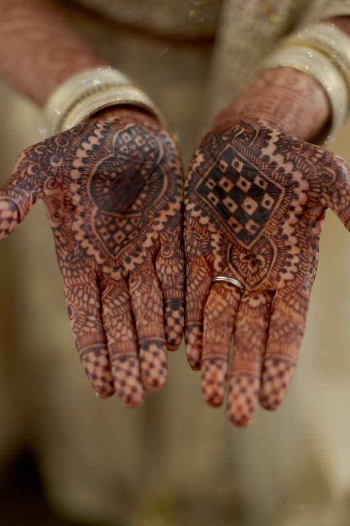 Indian bride in the USA wears mehendi on her hands.