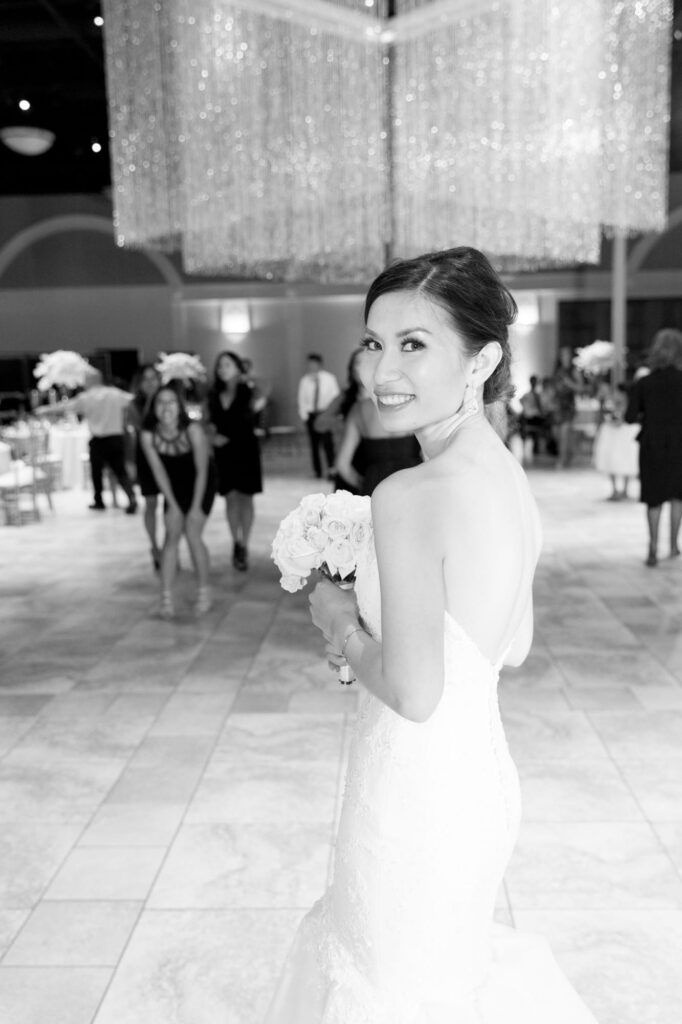 Elegant bride at her afterparty smiles at Robin Jolin's camera.