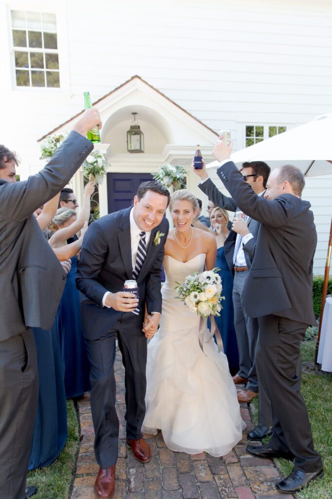 Bride and groom joyfully pass through their exuberant wedding guests.