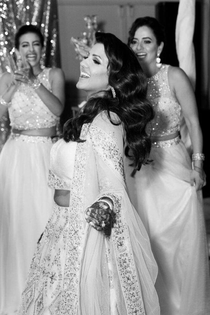 Bride shows her dance moves while bridesmaids encourage her from behind.